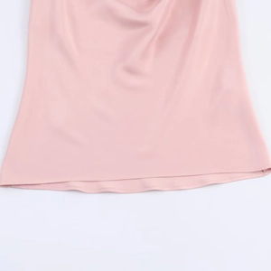 Detailansicht eines rosa Satin-Oberteils mit Perlen und Fokus auf Saumverarbeitung