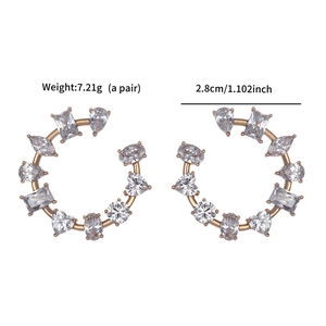 Detail view of gold C-shaped earrings featuring multi-shape clear cubic zirconia crystals