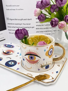 Detailed view of evil eye ceramic coffee cup set with golden rim and matching spoon