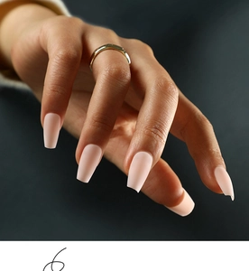 Matte nude pink short coffin press-on nails shown on hand with a gold ring