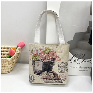 Detail of floral tapestry handbag with bird pattern and daily quote in natural light