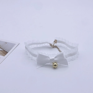 Close-up of white lace choker with satin bow and golden bell for costume dress up