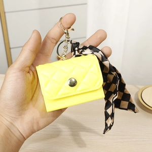 Detail of yellow quilted mini pouch keychain with checkerboard ribbon and gold hardware