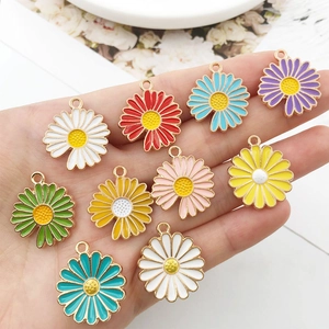 Macro shot of colorful enamel daisy charms with gold metal edges for DIY jewelry making