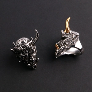 Detailed close-up of gothic demon mask rings in silver and gold-horned finishes