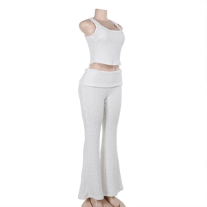 Detail of white two-piece lounge set showing textured fabric on top and wide-leg trousers