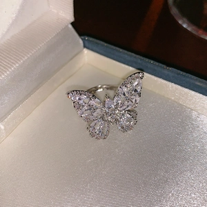 Macro d'une bague papillon en zircon étincelant sur un écrin à bijoux blanc élégant