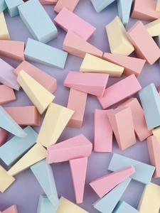 Macro view of pastel triangle makeup sponges showing fine texture and density