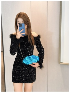 Detail of a bright blue metallic geometric clutch bag paired with a black sequin dress