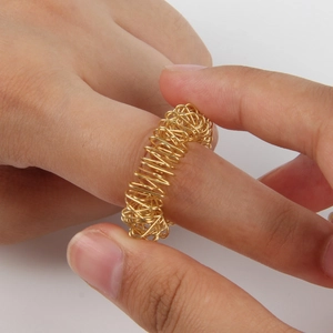 Close-up of golden acupressure ring being rolled on a finger for stress relief massage