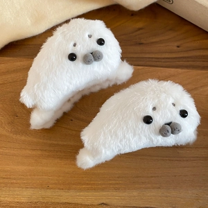 Close-up of white plush seal hair claws with soft faux fur and cute bead eyes detail