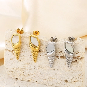Macro view of shell-shaped earrings with mother of pearl inlay on marble display