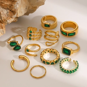 Set of 11 gold vintage stainless steel rings with green zircon on natural rock props