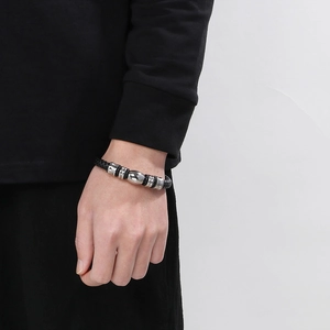Gros plan d'un bracelet en cuir tressé noir pour homme avec des perles métalliques