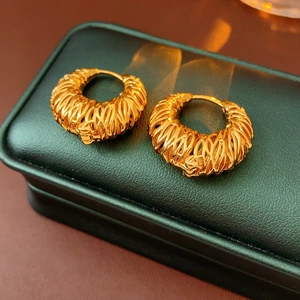 Detailed close-up of 18k gold plated hollow hoop earrings with intricate woven texture