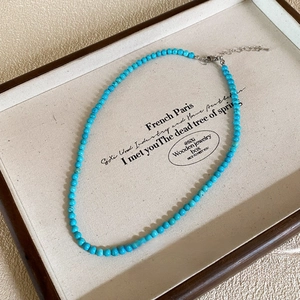 Close-up of turquoise bead necklace with silver lobster clasp and extension chain
