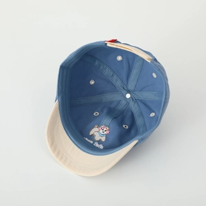 Detail of baby baseball cap interior showing blue and beige cotton fabric and stitching