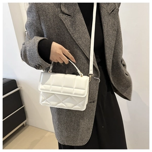 Chic white quilted shoulder bag styled with a grey herringbone blazer and top handle