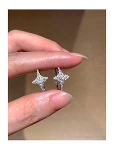 Close-up of silver star-shaped earrings with micro-inlaid cubic zirconia stones