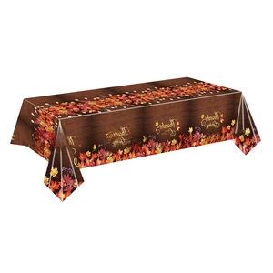Detail of Thanksgiving tablecloth featuring autumn maple leaves on a dark wood grain pattern