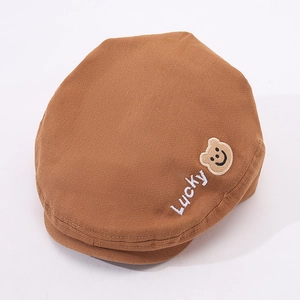 Dettaglio del cappello in cotone marrone con ricamo Lucky e toppa a forma di orso