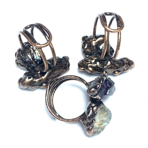 Detail of vintage bronze adjustable rings with amethyst and green crystal stones