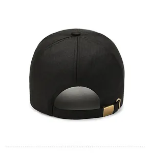 Close-up of the adjustable copper buckle and cotton texture on a black baseball cap