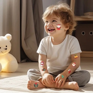 Toddler showing colorful Christmas temporary tattoos with Santa and snowman patterns