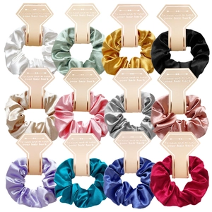 Set of 12 colorful satin scrunchies displayed on cream cards in a grid layout