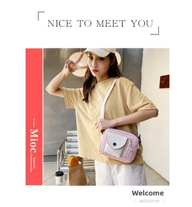 Detail view of pink and grey canvas bucket bag with adjustable white shoulder strap