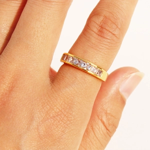 Elegant gold-plated ring with square zircon stones worn on finger, minimalist style