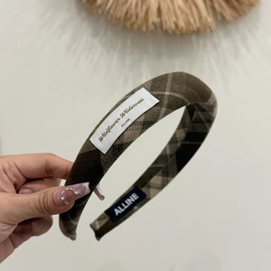 Detail shot of brown plaid fabric headband showing textile texture and fabric label