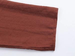 Detailed macro view of long sleeves showing the brown cotton linen fabric texture and stitching