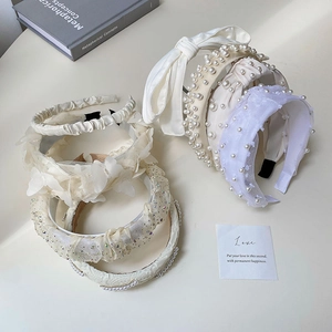 Detailed close-up of premium pearl headbands with lace bows and satin details