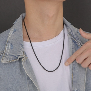 Close-up of a 3mm matte black stainless steel woven chain necklace worn by a male model