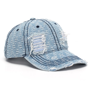 Close-up of distressed light blue denim baseball cap featuring ripped details and fringe edges