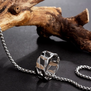 Detail view of a silver chain-style punk titanium ring on a textured background