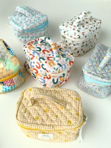 Collection of quilted floral and plaid makeup bags with top handles and zip closures