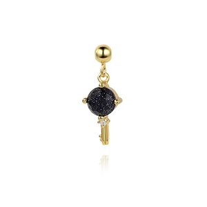 Macro view of gold S925 silver key pendant with dark blue stone and sparkling zircon detail