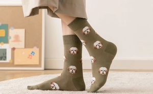Close-up of olive green socks with cute cartoon dog patterns and soft cotton texture