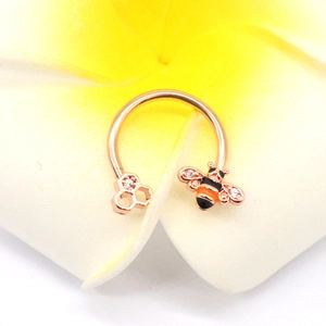 Rose gold horseshoe nose ring featuring a honey bee and honeycomb on a frangipani flower