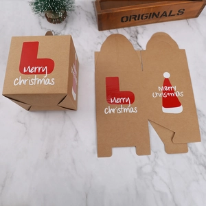 Flat lay of festive Kraft paper Christmas boxes with red stocking prints and pine decor