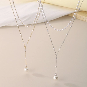 Detail showing Y-shaped gold and silver pearl pendant necklaces with elegant tassel drop