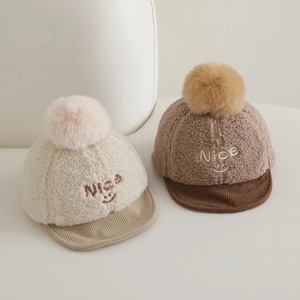 Détail de casquettes bébé en laine d'agneau avec broderie Nice, smiley et pompons moelleux