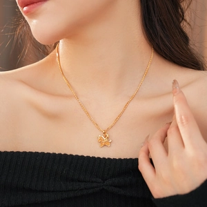 Close-up of golden necklace with a detailed horse pendant and sparkling crystals on model