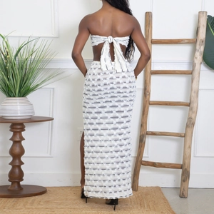 Back view of a white knitted two-piece set with tie-up crop top and slim fit maxi skirt