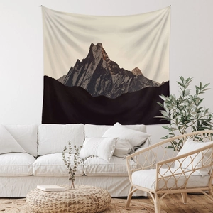 Detail of snowy mountain peaks tapestry hanging above a sofa in a minimalist living room
