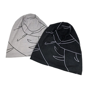 Flat lay of gray and black knit hats with abstract patterns and waffle texture