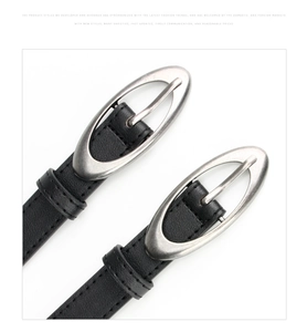 Detail of two black leather belts featuring vintage silver oval buckles and fine stitching