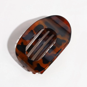 Close-up of leopard pattern hair claw clip with cutout details on white background
